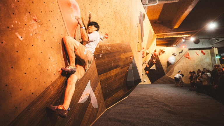 Kokoro Fujii grimpe un circuit de coimpétition d'escalade de Haut Niveau à Climbing District dans la salled es Buttes- Chaumont à Paris 19e, proche du canal Saint Martin.