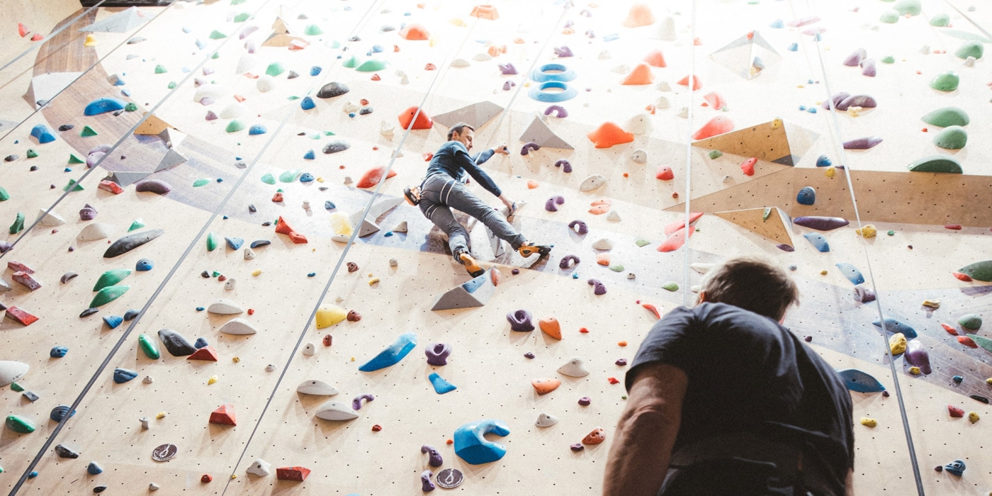 Grimpeur sur le mur d'escalade sur enrouleurs à Climbing District Saint-Lazare.