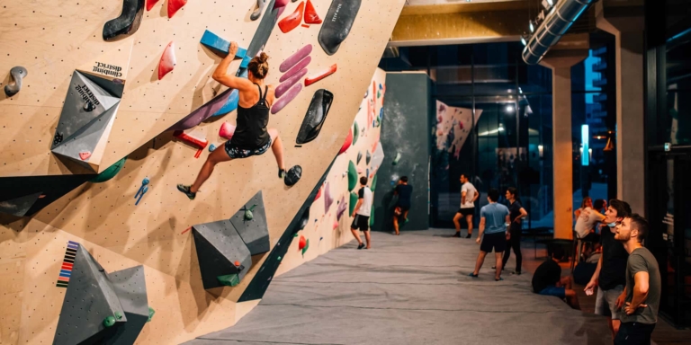 Grimpeuse débutante sur la structure d'escalade de Climbing District aux Batignolles à Paris