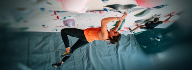 Grimpeuse sur le mur d'escalade Climbing District