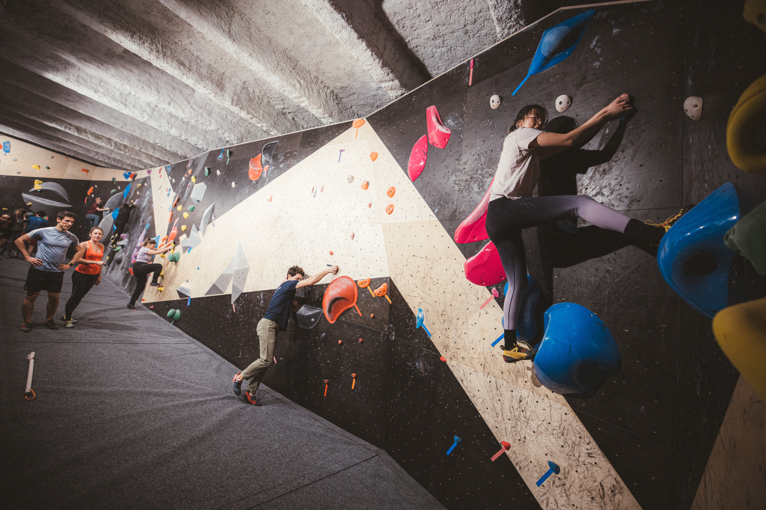 Grimpeurs sur le mur de la salle d'escalade Climbing District Bastille